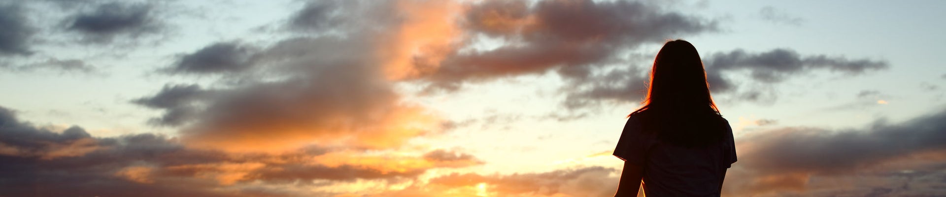 Back view portrait of a woman silhouette doing yoga at sunset in the mountain