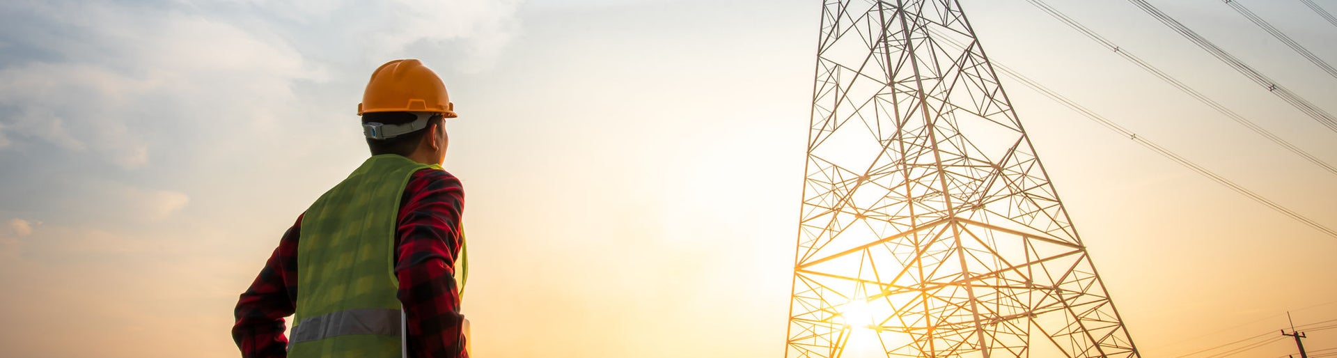Picture of an electrical engineer standing and watching at the electric power station to view the planning work by producing electricity at high voltage electricity poles.