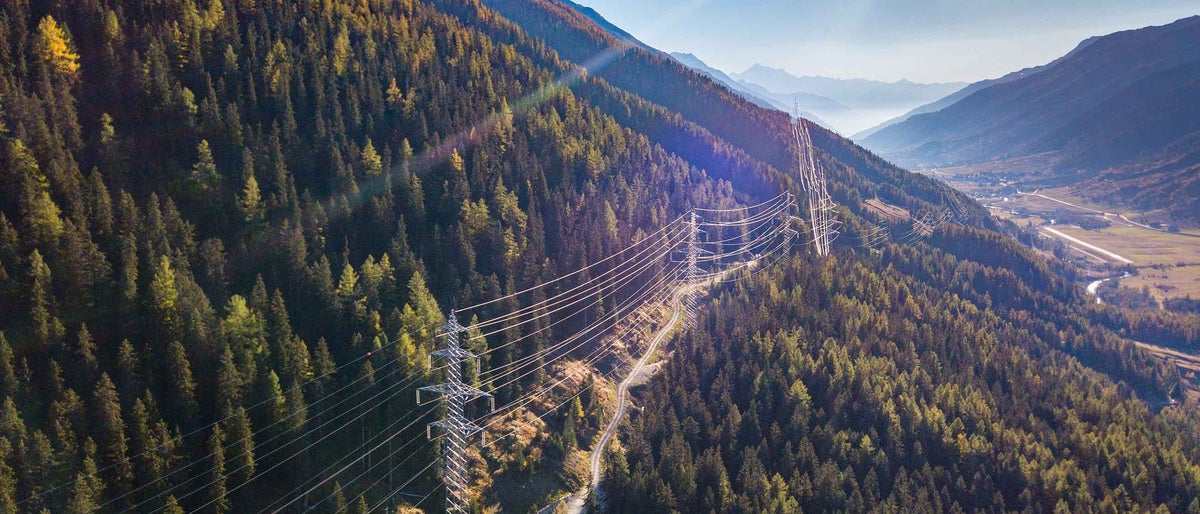 Aerial view of power line pylon in mountaineous area in Switzerland, Europe