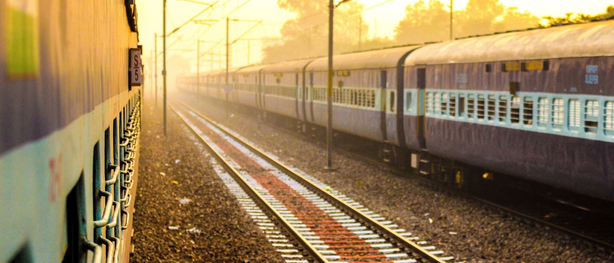 beautiful morning image of two Indian train with rail between them in yellowish morning light and a bit fogg. Perfect to show Indian railways system in news or article