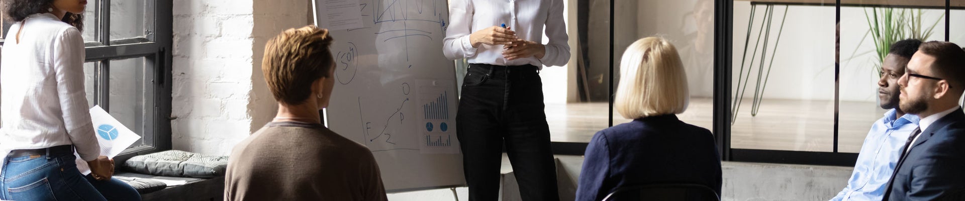 Confident lady business trainer coach leader give flip chart presentation consulting clients teaching employees training team people speaking explaining strategy at marketing workshop concept