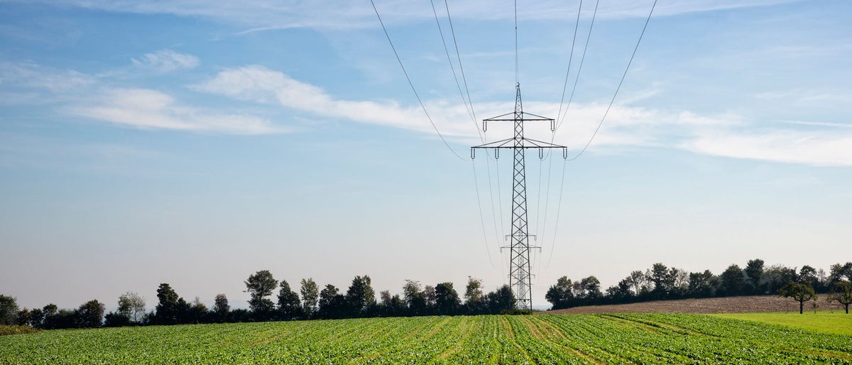 Transmission towers and power lines in agricultural fields.