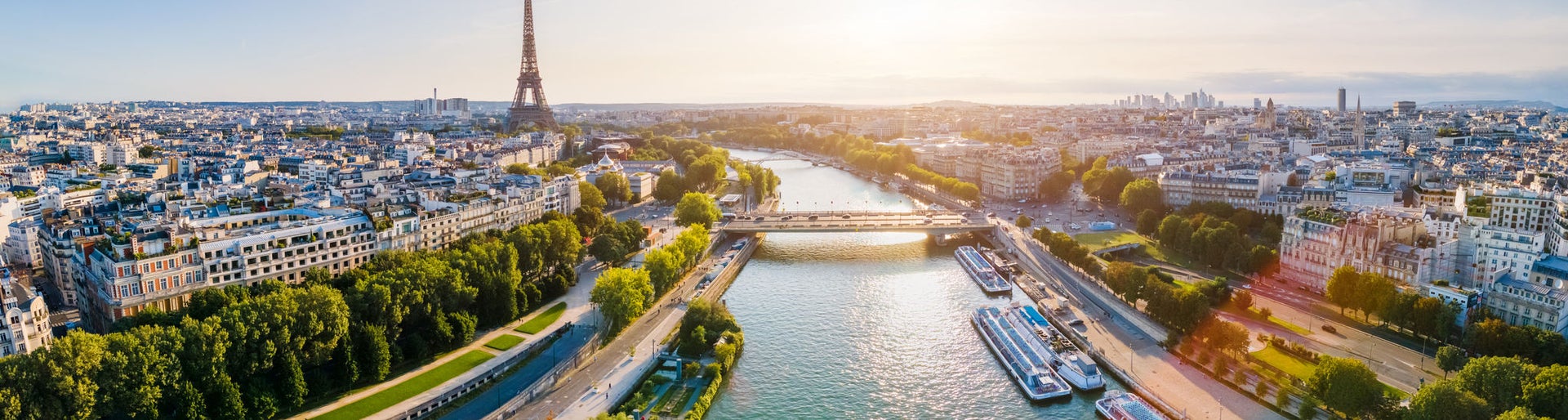 Paris aerial panorama with river Seine and Eiffel tower, France. Romantic summer holidays vacation destination. Panoramic view above historical Parisian buildings and landmarks with blue sky and sun