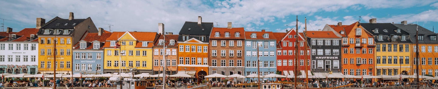 COPENHAGEN, DENMARK, SEPTEMBER 17, 2021: Copenhagen iconic view. Famous old Nyhavn port in the center of Copenhagen, Denmark during winter sunny day