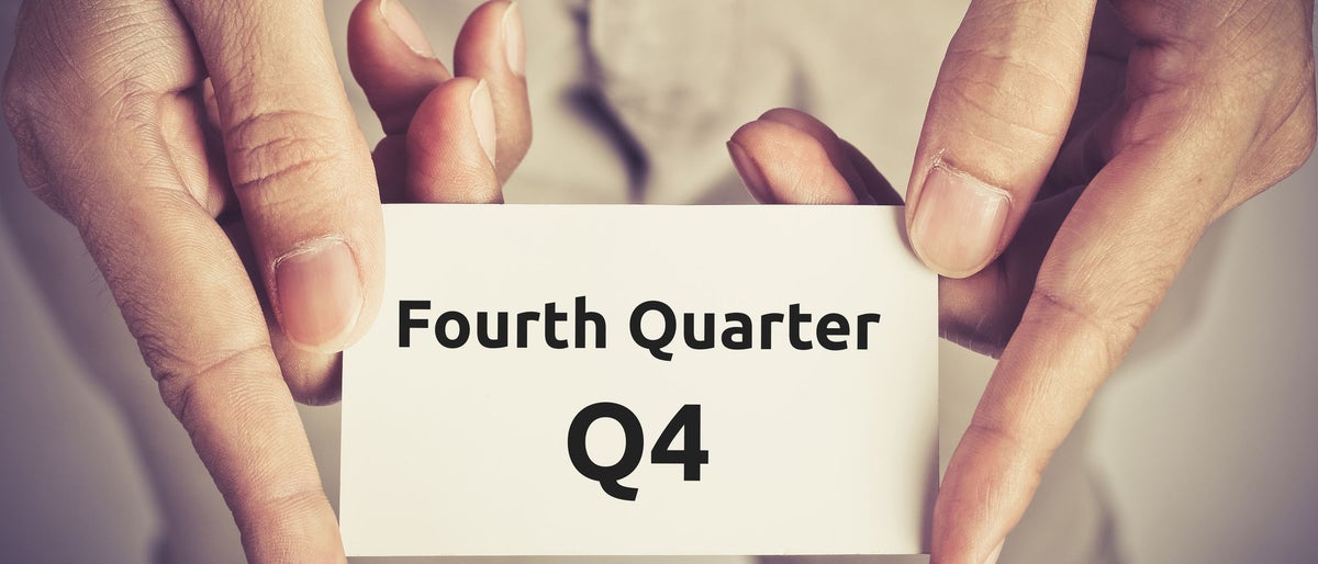 Fourth Quarter (Q4) of business - text on card hold by man 