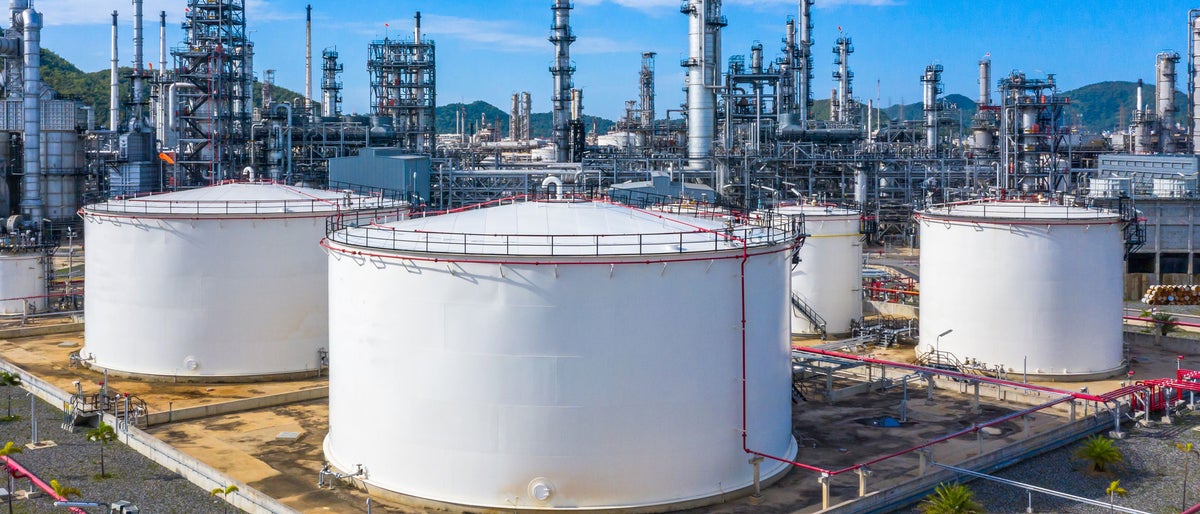Oil​ refinery​ and​ petrochemical​ architecture plant industrial with blue sky background, White oil and gas refinery tank, Oil refinery plant from industry zone business power and energy petroleum.