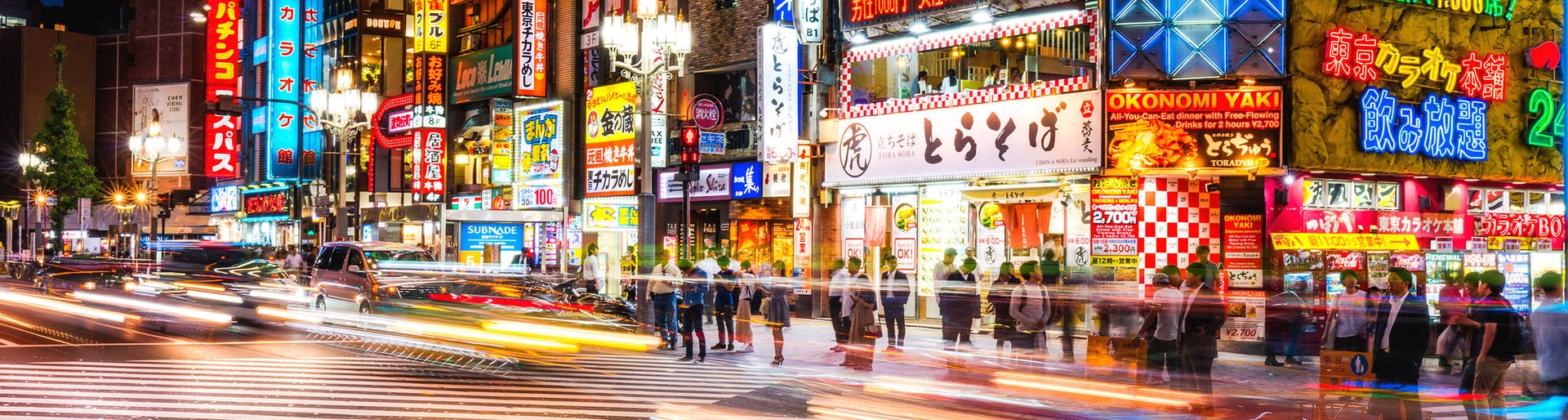Crowded streets of Shinjuku shopping district with blurred commuters at dusk 