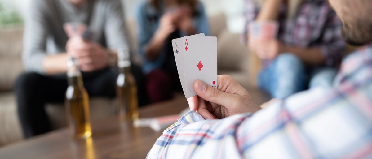 Groupe d’amis qui se détendent et jouent aux cartes ensemble. Des jeunes qui se tiennent ensemble; Shutterstock ID 1562995666; Bon de commande : -