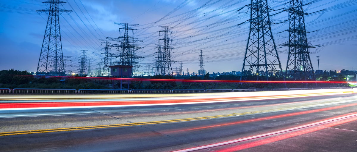 High voltage, high speed road car track in the background of high voltage towers