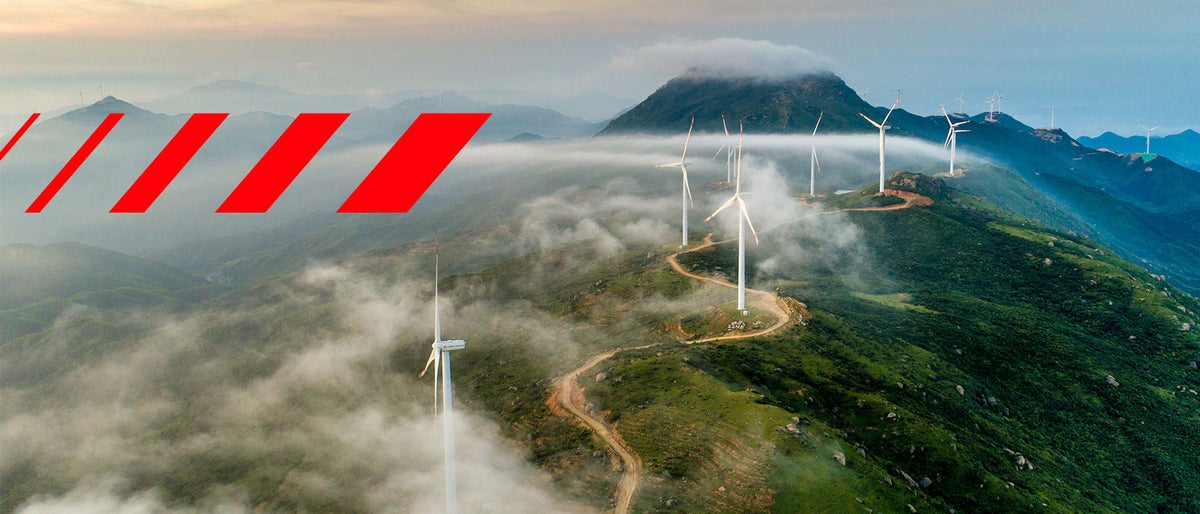 Hitachi Energy signature red pattern on mountain with wind turbines