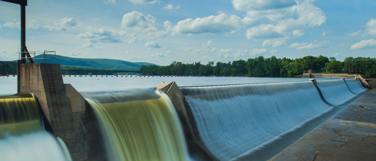 Hydroelectric power energy plant with turbines and water spills for generating green electricity. Free, green adn ecological energy concept. Climate changes