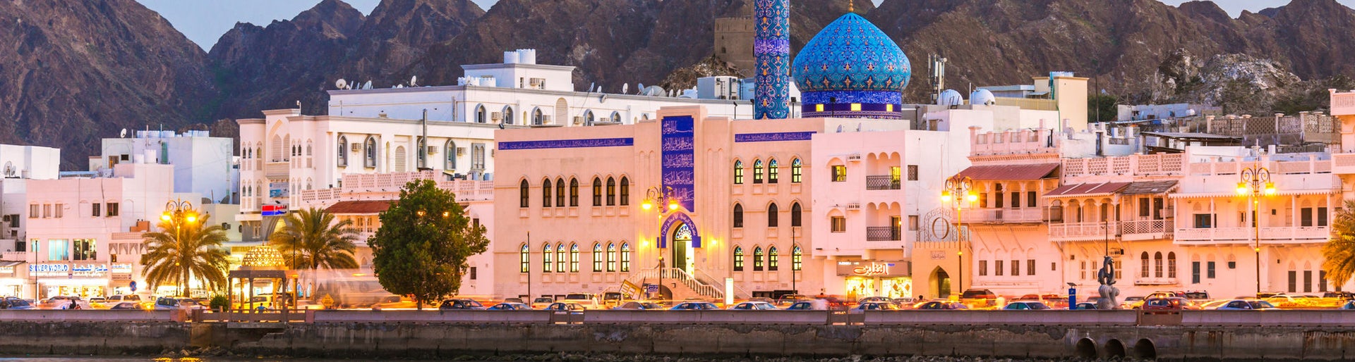 Oman, Muscat. Cityscape of Mutrah harbour, at dusk