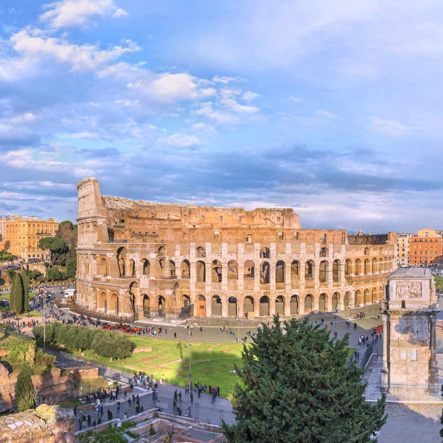Amazing aerial panoramnic view on the Great Roman Colosseum ( Coliseum, Colosseo ,also known as Flavian Amphitheatre ) at sunset. Famous world landmark. Scenic urban landscape. Rome. Italy. Europe