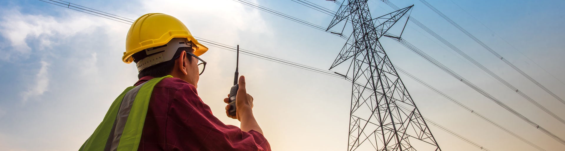 Picture of an electrical engineer standing and watching at the electric power station to view the planning work by producing electricity at high voltage electricity poles.