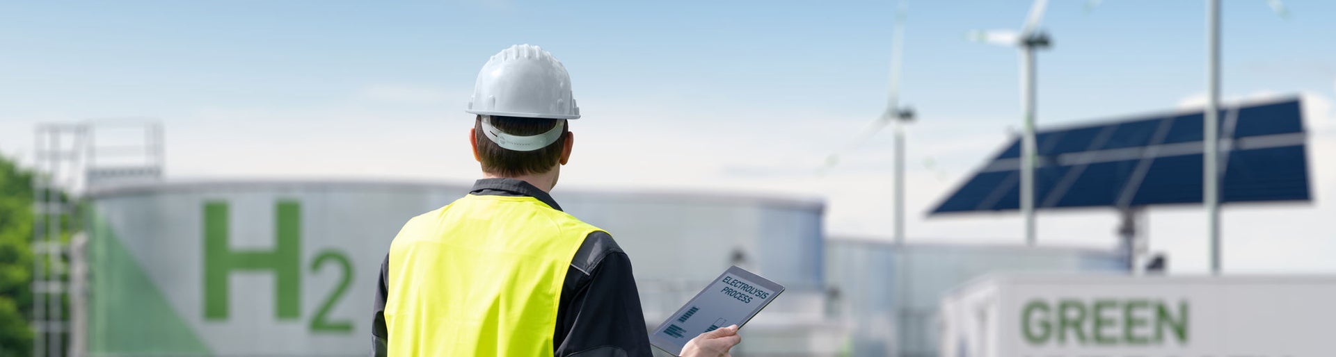 Engineer with tablet computer on a background of Green Hydrogen factory