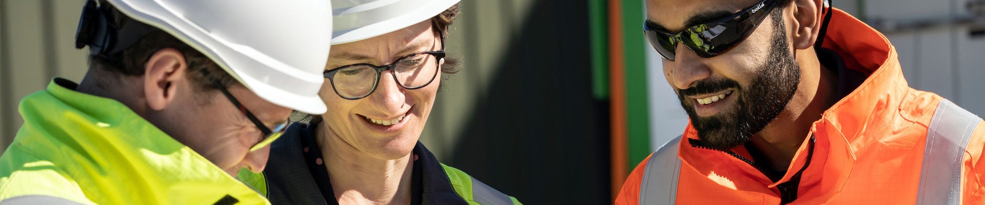 Young woman in an apron in a greenhouse conducts research into the growth of vegetables. Summer assignment for a student