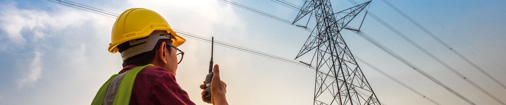 Picture of an electrical engineer standing and watching at the electric power station to view the planning work by producing electricity at high voltage electricity poles.