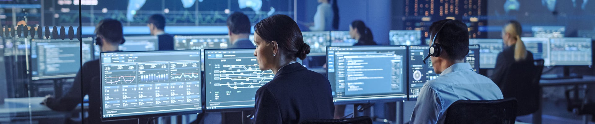 Team of Professional Computer Data Science Engineers Work on Desktops with Screens Showing Charts, Graphs, Infographics, Technical Neural Data and Statistics. Low Key Control and Monitoring Room.