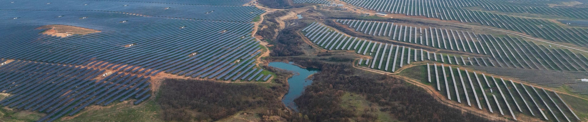 Young woman in an apron in a greenhouse conducts research into the growth of vegetables. Summer assignment for a student