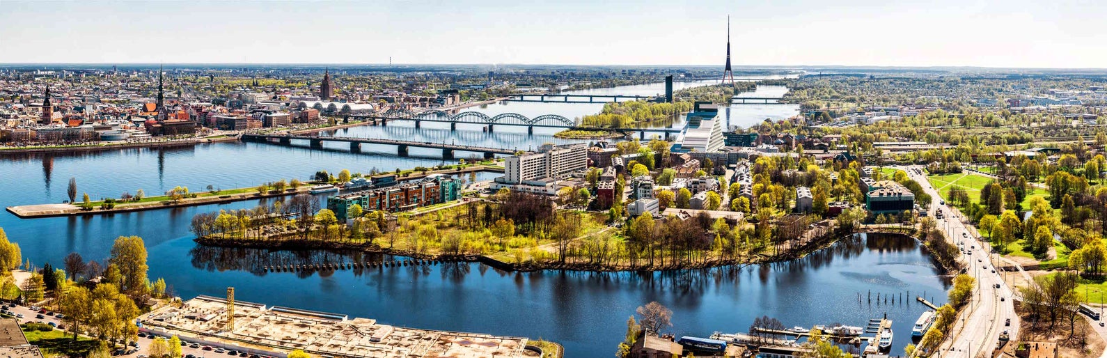 Panoramic aerial image horizontal photo of Riga cityscape centre capital of Latvia, Daugava river sunny spring day, banner for website header design, copy space. European city, horizon over land
