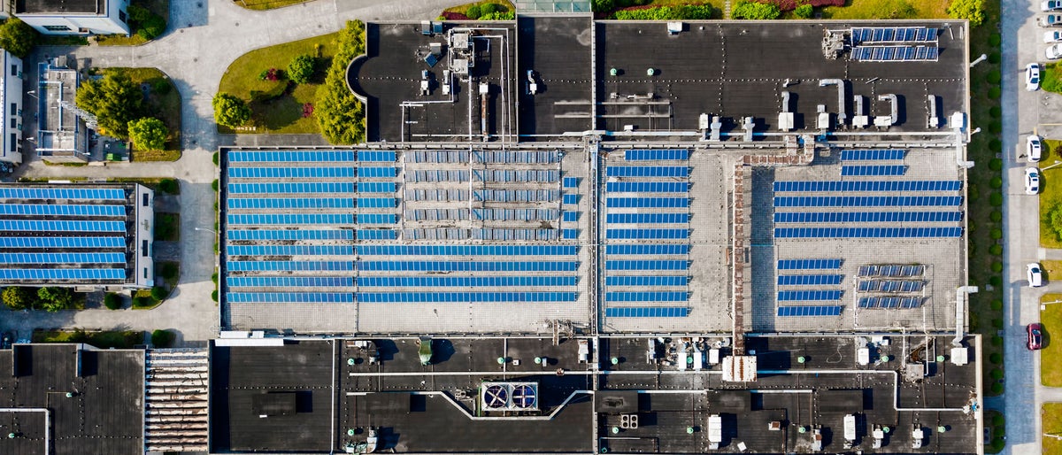 Aerial view of solar panels installed on factory rooftop