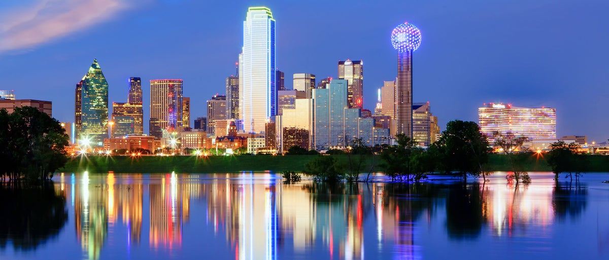 Downtown Dallas Texas reflects on the full Trinity River.